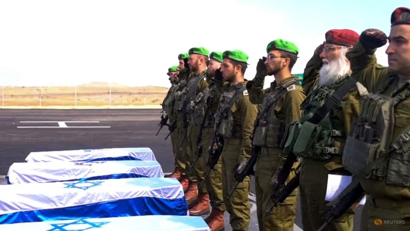 Israeli soldiers salute as they receive the coffins with the bodies of deceased hostages, identified at the time by Palestinian militant groups as Oded Lifschitz, Shiri Bibas and her two children, Kfir and Ariel Bibas on Feb 20, 2025. (Photo: Reuters/Handout/GPO)