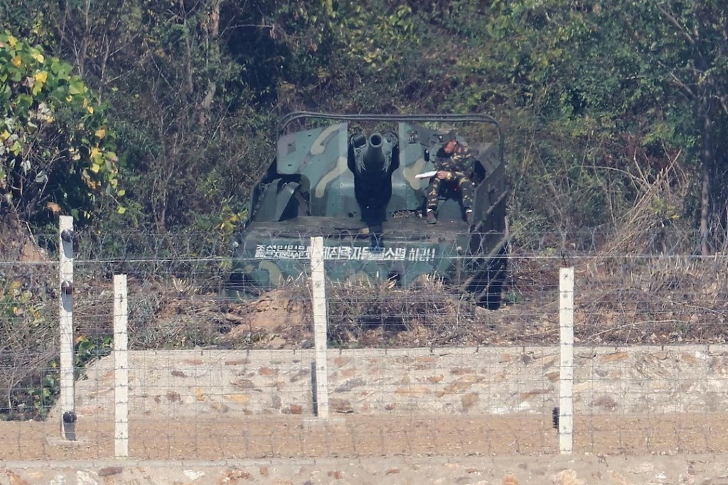  A North Korean soldier sits on a self-propelled 122-mm howitzer with the words that read as "Destroy the US imperialist aggressors, the sworn enemies of the Korean people!" and is deployed along the border separating the two Koreas, as seen from an observation deck in Gimpo, South Korea, October 27, 2026. REUTERS/Kim Hong-Ji