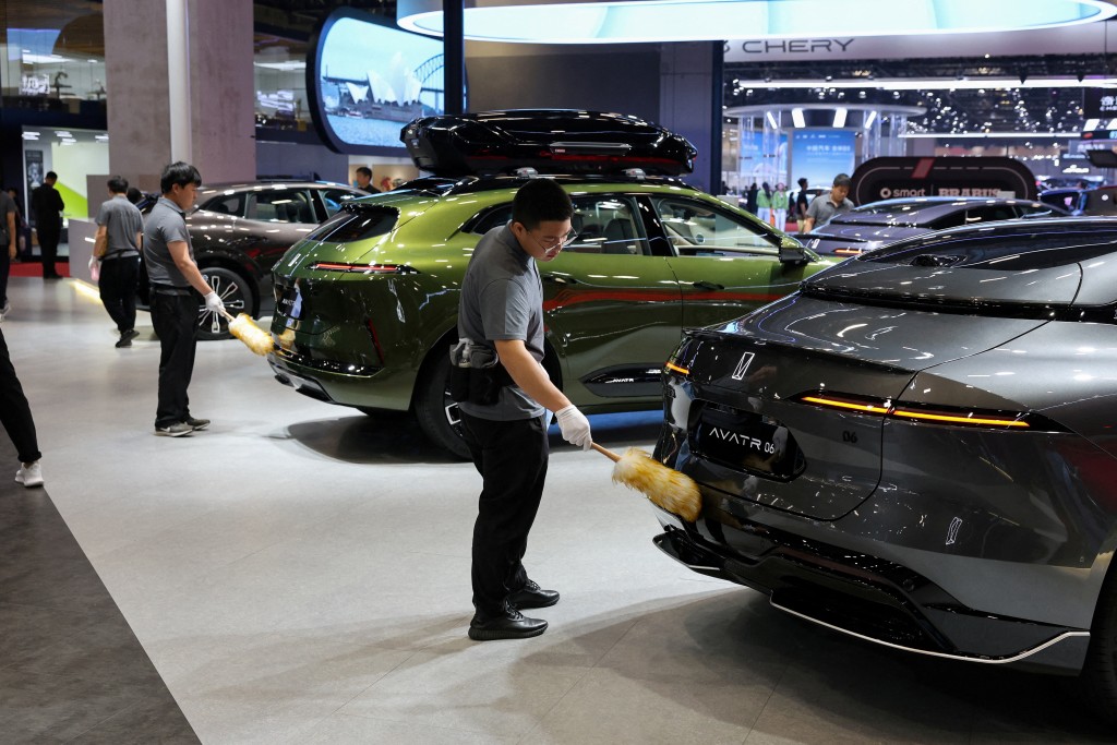 Workers clean cars at the Avatr booth during a media day for the Auto Shanghai show in Shanghai, China April 24, 2025. REUTERS