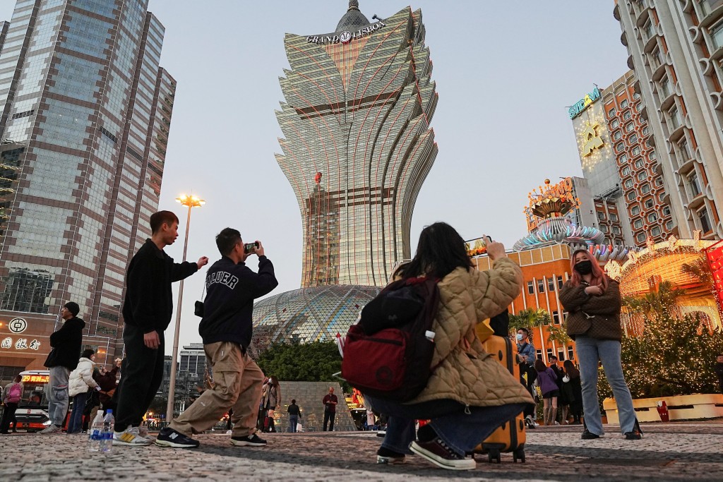 Visitors pose for photos outside the Grand Lisboa casino operated by SJM Holdings during Lunar New Year in Macau, China, January 24, 2023. REUTERS/Lam Yik  