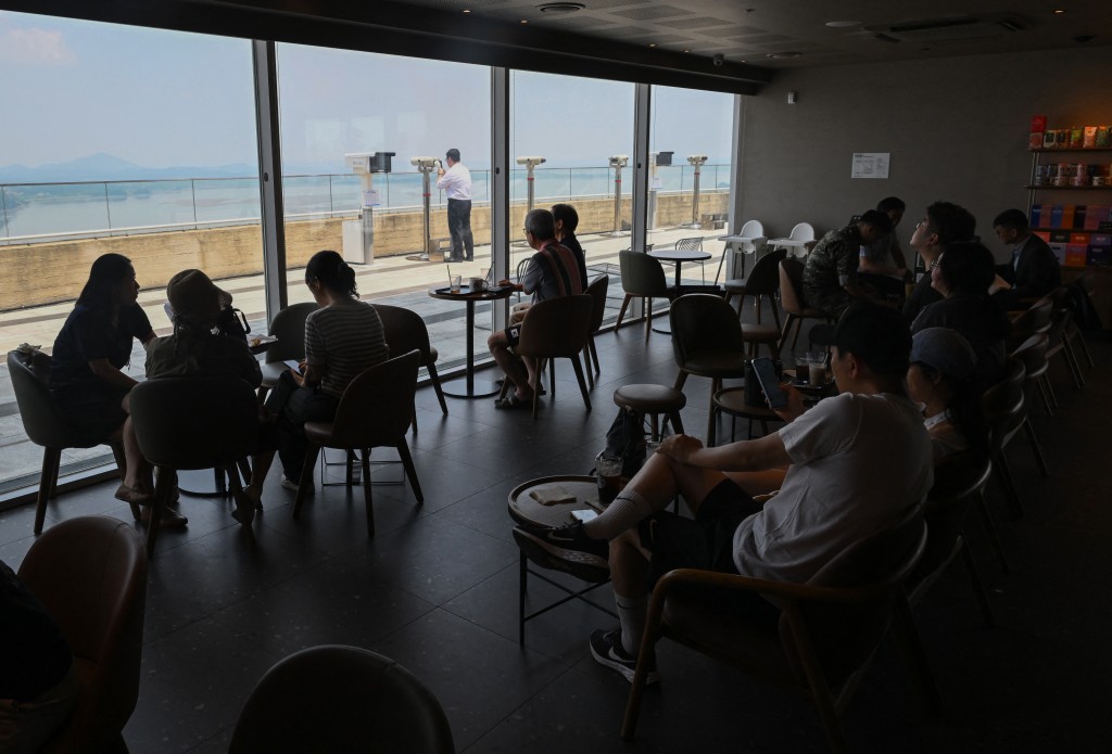 Photo by JUNG YEON-JE / AFP  Visitors sit in a Starbucks store offering a view of North Korea from a South Korean observation at Aegibong Peace Ecopark in Gimpo on July 1, 2026.