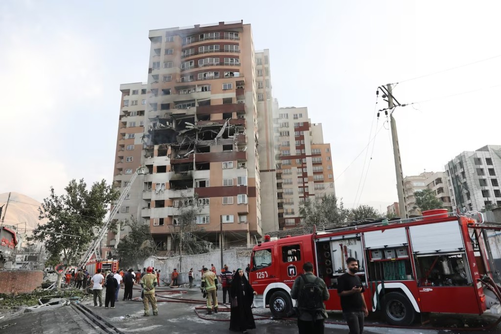 Firefighters work at the scene of a damaged building in the aftermath of Israeli strikes, in Tehran, Iran, June 13, 2025. (Majid Asgaripour/WANA via REUTERS)