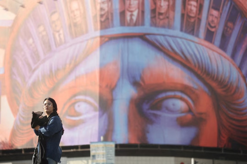  An Iranian woman walks past an anti-U.S. billboard on a street in Tehran, Iran, November 5, 2025. Majid Asgaripour/WANA (West Asia News Agency) via REUTERS /File Photo 