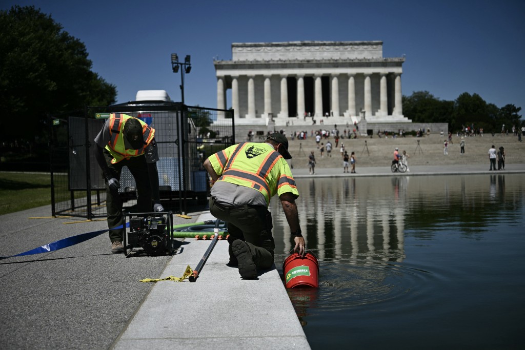 Photo by BRENDAN SMIALOWSKI / AFP Members of the National Park Service work near the Lincoln Memorial Reflecting Pool following the completion of recent renovations in Washington, DC, on June 16, 2026.
