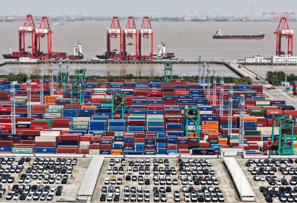 A drone view shows electric vehicles (EV) for export and containers sitting at a port in Shanghai, China April 13, 2025. China Daily via REUTERS ATTENTION EDITORS - THIS PICTURE WAS PROVIDED BY A THIRD PARTY.