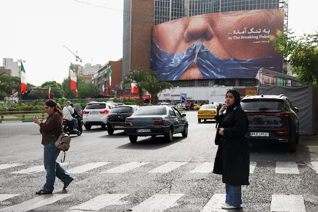 A woman walks past an anti-U.S. billboard depicting U.S. President Donald Trump and the Strait of Hormuz, in Tehran, Iran, May 17, 2026. Majid Asgaripour/WANA (West Asia News Agency) via REUTERS