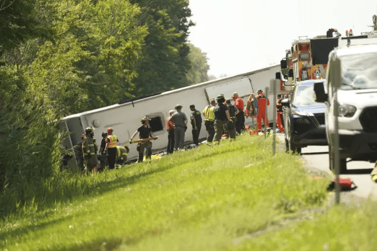 First responders work to rescue victims at the scene of a tour bus that crashed and rolled over on a New York State highway near the northern city of Buffalo on Friday [Libby March/Buffalo News via AP Photo]