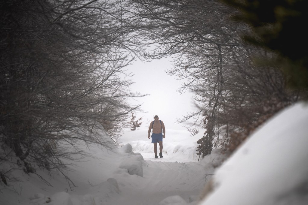 Photo by OLIVER BUNIC / AFP  Serbian archaeologist Vladimir Stevanovic, known on social media as "Serbia's Iceman", hiking wearing only boots, shorts and a backpack on thick snow at the Besna Kobila mountain in Serbia's far south, near the city of Vranje, on January 30, 2026.