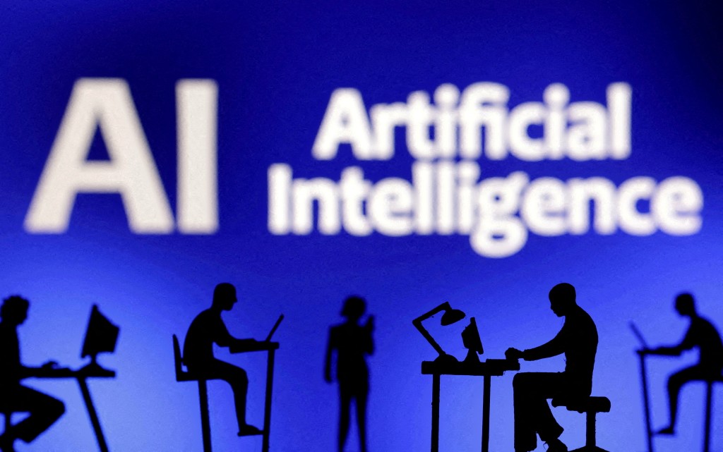 Figurines with computers and smartphones are seen in front of the words "Artificial Intelligence AI" in this illustration. (Reuters)