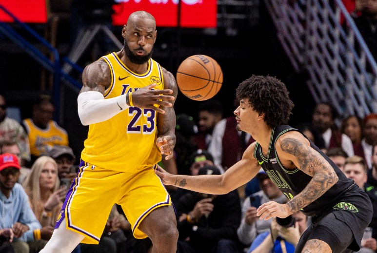 LeBron James throws a pass against New Orleans Pelicans guard Micah Peavy. REUTERS