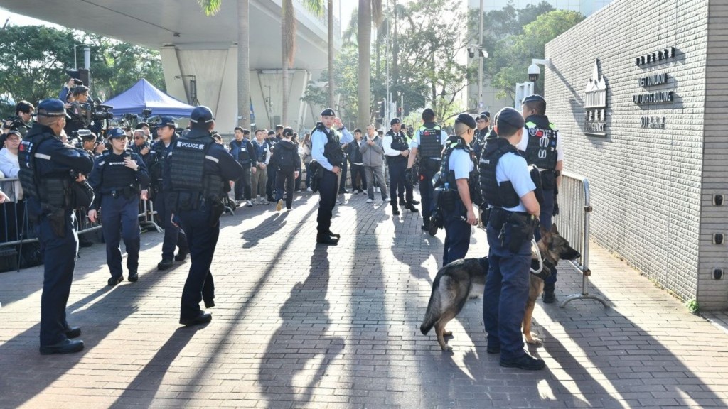 Police are deployed outside the West Kowloon Magistrates’ Courts building. sing tao