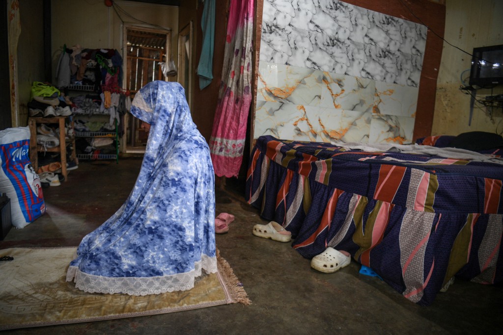 Photo by TED ALJIBE / AFP. In this photo taken on September 7, 2026, Annalyn Pangandaman prays inside her house at a temporary resettlement area in Marawi, Lanao del sur province on southern island of Mindanao.