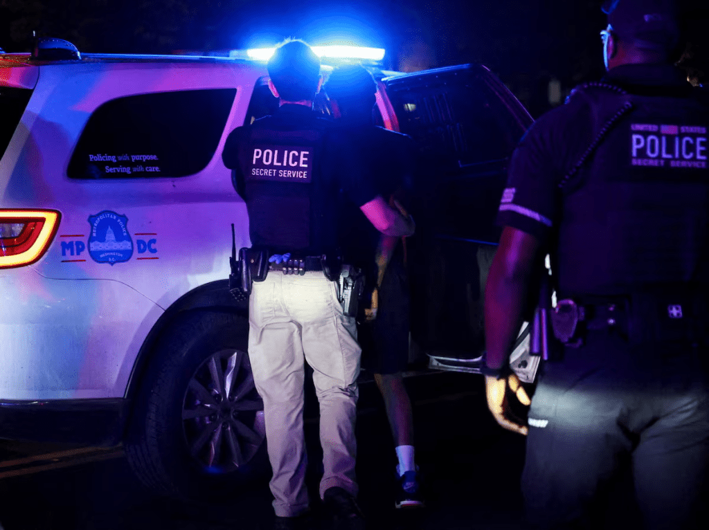Police detain a person in the Brightwood neighborhood after U.S. President Donald Trump's announcement of the federal takeover of the Metropolitan Police Department under the Home Rule Act and the deployment of the National Guard to assist in crime prevention in the nation's capital, in Washington, D.C., U.S., August 14, 2025. REUTERS/Evelyn Hockstein/File Photo