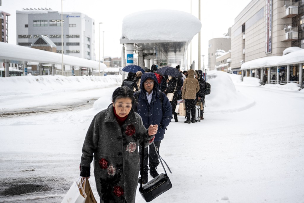 Pedestrian walk at a snow covered bus terminal in Aomori city, Aomori prefecture on January 30, 2026. (Photo by Philip FONG / AFP)