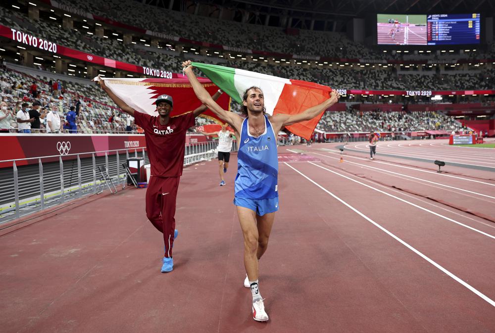 Gold medalist Mutaz Barshim, left, of Qatar and silver medalist Gianmarco Tamberi of Italy celebrate on the track after the final of the men's high jump at the 2020 Summer Olympics, Sunday, Aug. 1, 2021, in Tokyo, Japan.