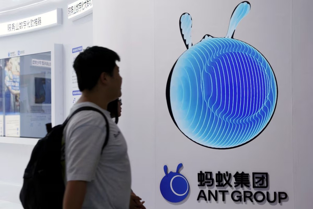 People walk past the Ant Group logo at its booth at the China International Fair for Trade in Services (CIFTIS) in Beijing, China. REUTERS
