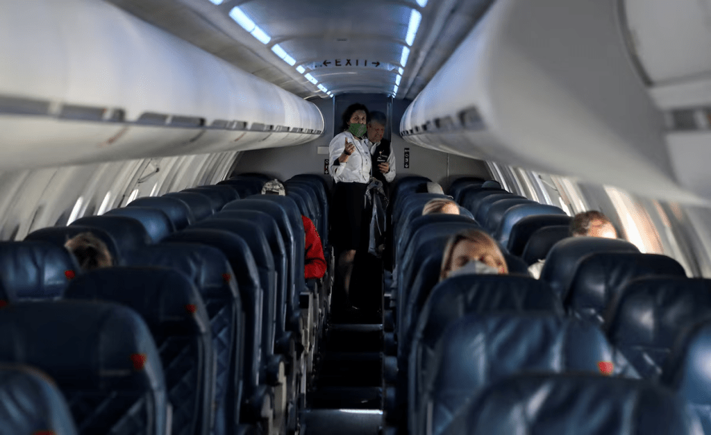 Flight attendants talk on a Delta Airlines flight operated by SkyWest Airlines during a flight departing from Salt Lake City, Utah, U.S. April 11, 2020. REUTERS/Jim Urquhart/File Photo