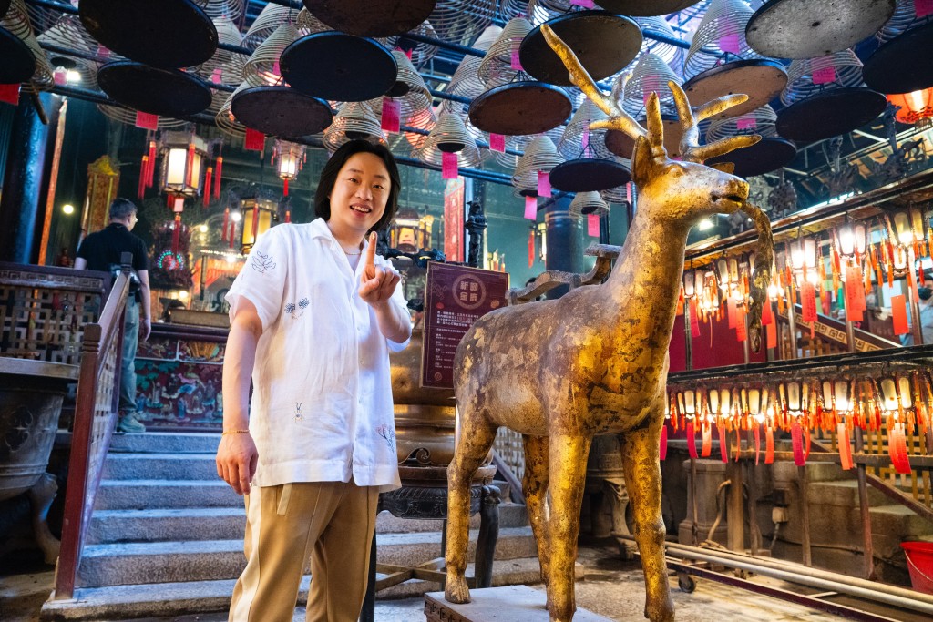 (HKTB) Jimmy applies gold foil to the Golden Deer at Man Mo Temple.