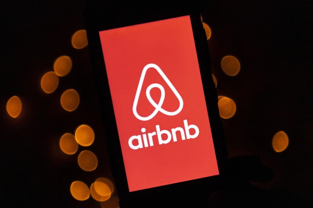 Photo by LIONEL BONAVENTURE / AFP  This illustration picture taken on November 22, 2019, shows the logo of the online lodging service Airbnb displayed on a smartphone in Paris.