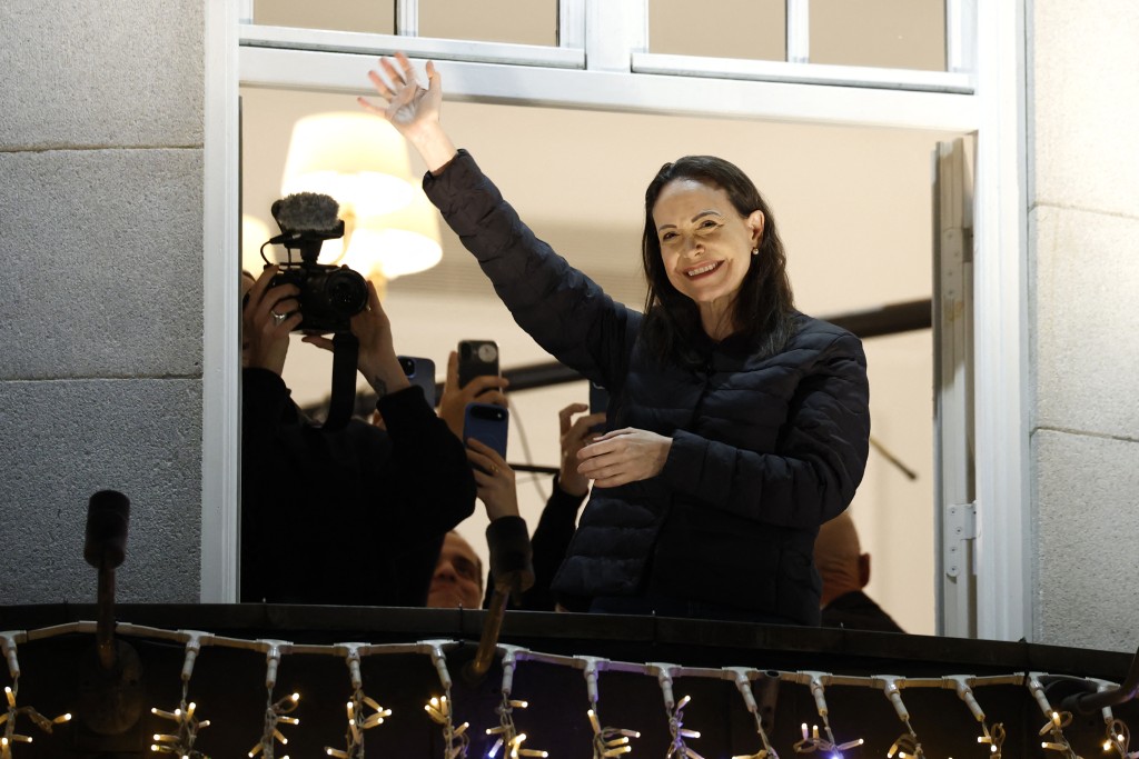 Photo by ODD ANDERSEN / AFP Nobel peace laureate Maria Corina Machado greets supporters from a balcony of the Grand Hotel in Oslo, Norway, early on December 11, 2025.