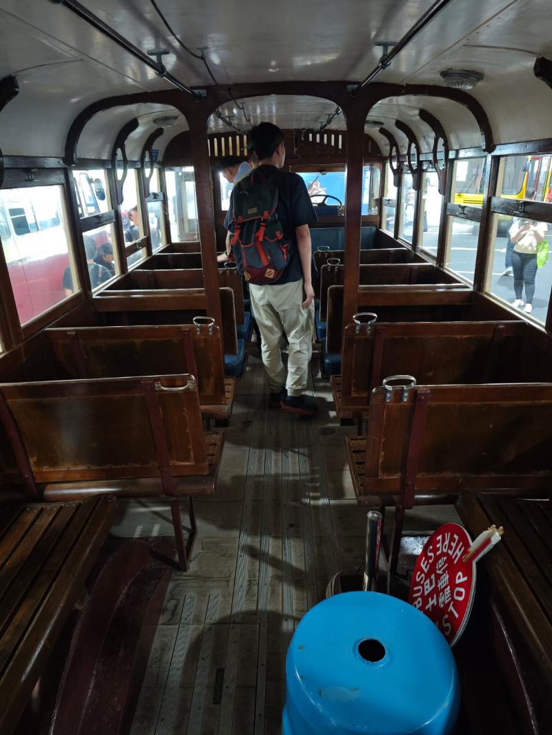 The interior of Tilling Stevens bus that includes wooden seats.