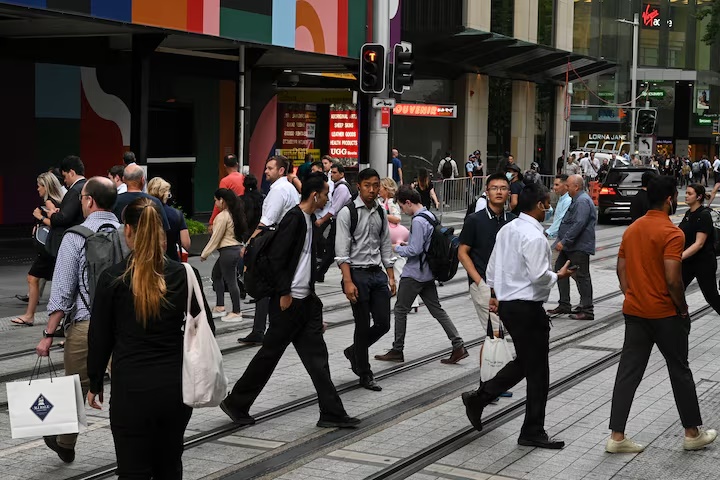 File photo: People cross a street in the city centre following further easing of coronavirus disease (COVID-19) restrictions in Sydney, Australia, December 10, 2020. REUTERS/Loren Elliott/File photo