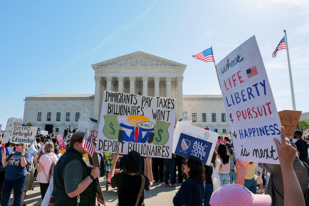 Demonstrators hold placards outside the U.S. Supreme Court building as the court hears oral arguments on the legality of the Trump administration's effort to limit birthright citizenship for the children of immigrants, in Washington, D.C., U.S., April 1, 2026. REUTERS/Kylie Cooper