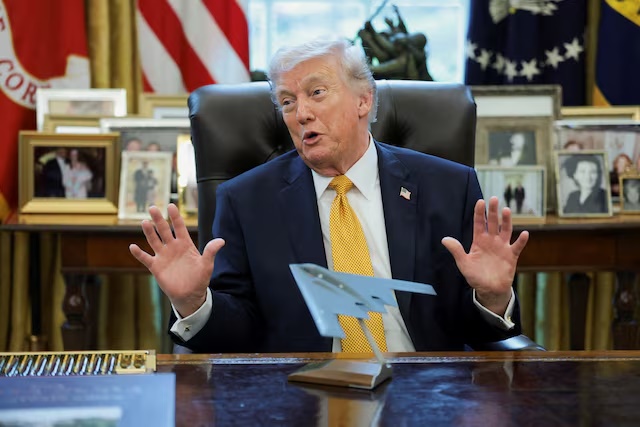 U.S. President Donald Trump gestures in front of a model of a B‑2 bomber commemorating "Operation Midnight Hammer" during an event to sign an executive order creating an anti‑fraud task force headed by U.S. Vice President JD Vance in the Oval Office at the White House in Washington, D.C., U.S., March 16, 2026. REUTERS/Jonathan Ernst