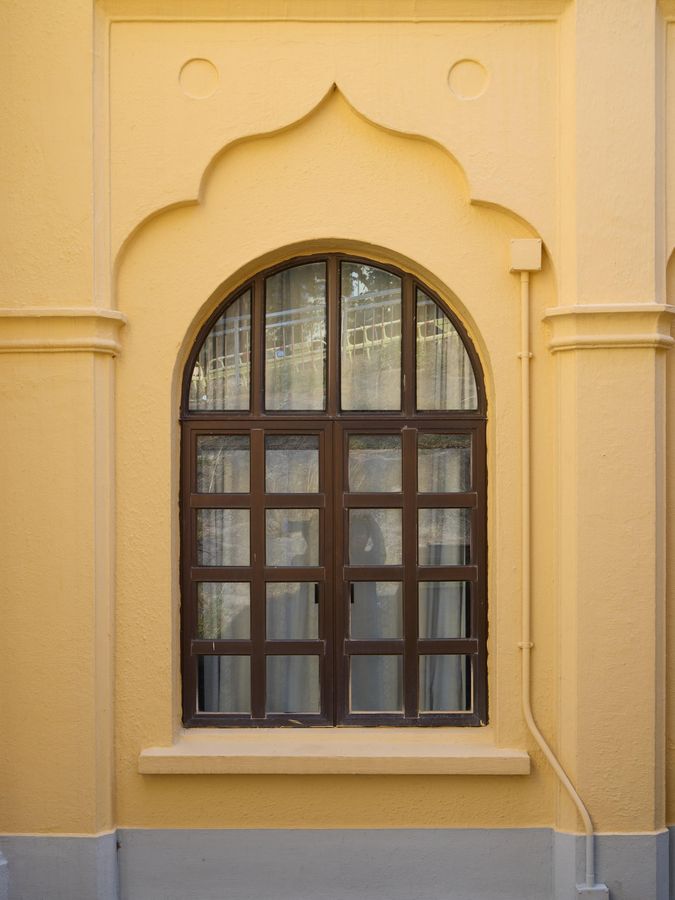 Photo shows the mosque’s arched window opening surrounded by decorative geometric patterns, an ogee arch and moulding.