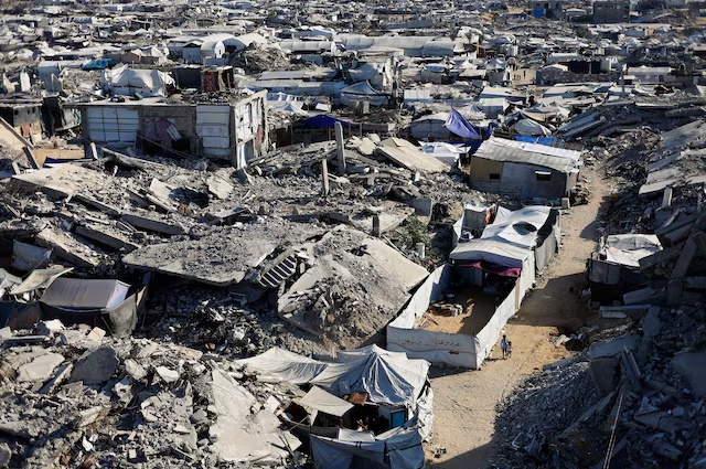 Palestinian children walk past the rubble of residential buildings destroyed during the war, at Jabalia refugee camp in the northern Gaza Strip, August 5, 2026. REUTERS/Mahmoud Issa
