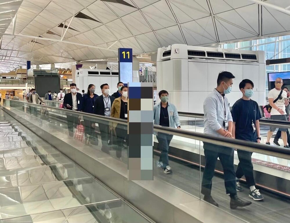 The prisoner, pixelated, being escorted through the airport on the way to his flight. The prisoner, pixelated, being escorted through the airport on the way to his flight.