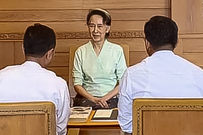 Photo by HANDOUT / MYANMAR'S MINISTRY OF HOME AFFAIRS / AFP  This handout photograph released on October 19, 2026 by Myanmar's Ministry of Home Affairs shows detained former State Counsellor Aung San Suu Kyi (C) meeting with Ministry officials in Naypyidaw, where she received a package from Britain's King Charles III.