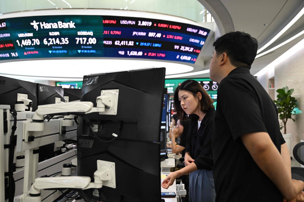 Currency dealers watch monitors as an electronic screen shows South Korea's benchmark stock index (KOSPI) in a foreign exchange dealing room at the Hana Bank headquarters in Seoul on July 28, 2026. AFP