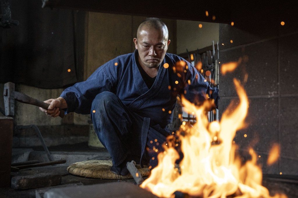Photo by YUICHI YAMAZAKI / AFP  This picture taken on January 9, 2026 shows swordsmith Akihira Kawasaki hammering steel to forge katana blades at his workshop in Misato, Saitama prefecture.