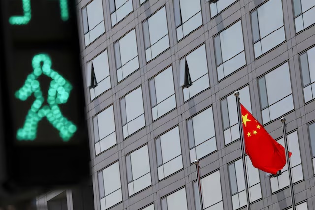 A Chinese national flag flutters outside the China Securities Regulatory Commission (CSRC) building on the Financial Street in Beijing, China July 9, 2021. REUTERS/Tingshu Wang/File Photo
