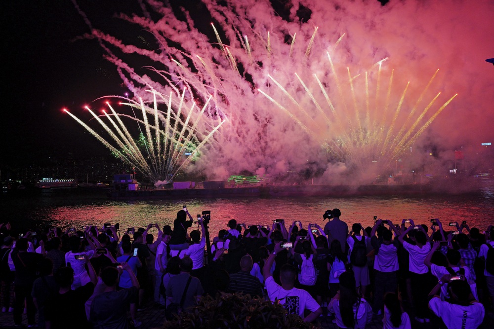 Tens of thousands watch the pyrotechnic show despite the bad weather. SING TAO