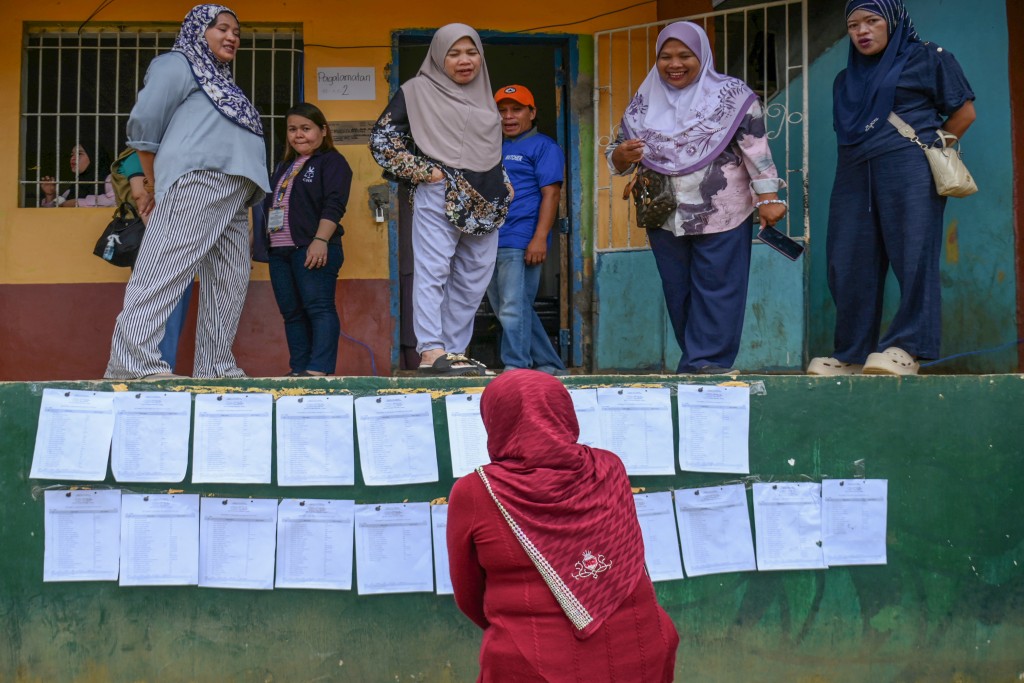 A voter looks for her precinct number posted on a wall of a school building in Saguiaran on the southern island of Mindanao on September 14, 2026.