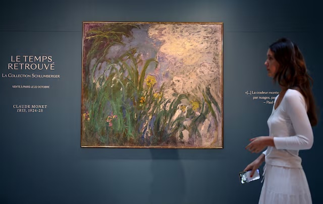 A visitor walks past the painting "Iris, 1924-1925" by French painter Claude Monet (1840-1926) during the presentation of 28 art works from the Schlumberger Collection ahead of the auction at Sotheby's auction house in Paris, France, September 17, 2026. REUTERS/Abdul Saboor