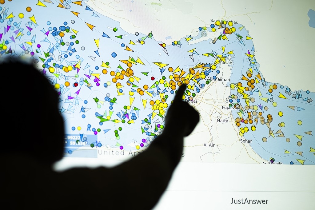 Photo by - / AFP  A photo illustration taken in Nicosia on May 4, 2026, shows a person in front of a large screen displaying vessel movements in the Strait of Hormuz on a ship-tracking website.