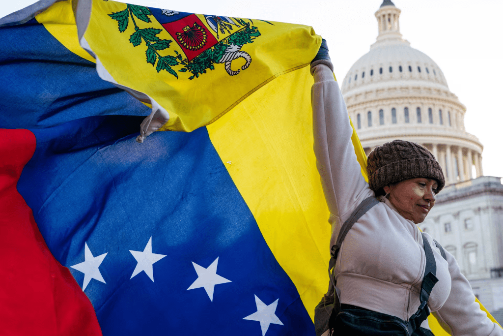 A woman holds a Venezuelan flag as people gather outside the U.S. Capitol during Venezuelan opposition leader Maria Corina Machado's meeting with U.S. senators, following an earlier meeting with U.S. President Donald Trump at the White House, in Washington, D.C., U.S., January 15, 2026. REUTERS/Elizabeth Frantz 