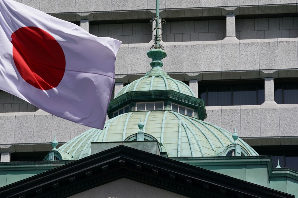 The Japanese national flag flutters in the wind on part of the Bank of Japan (BoJ) headquarters in Tokyo on April 28, 2026. (Photo by Kazuhiro NOGI / AFP)