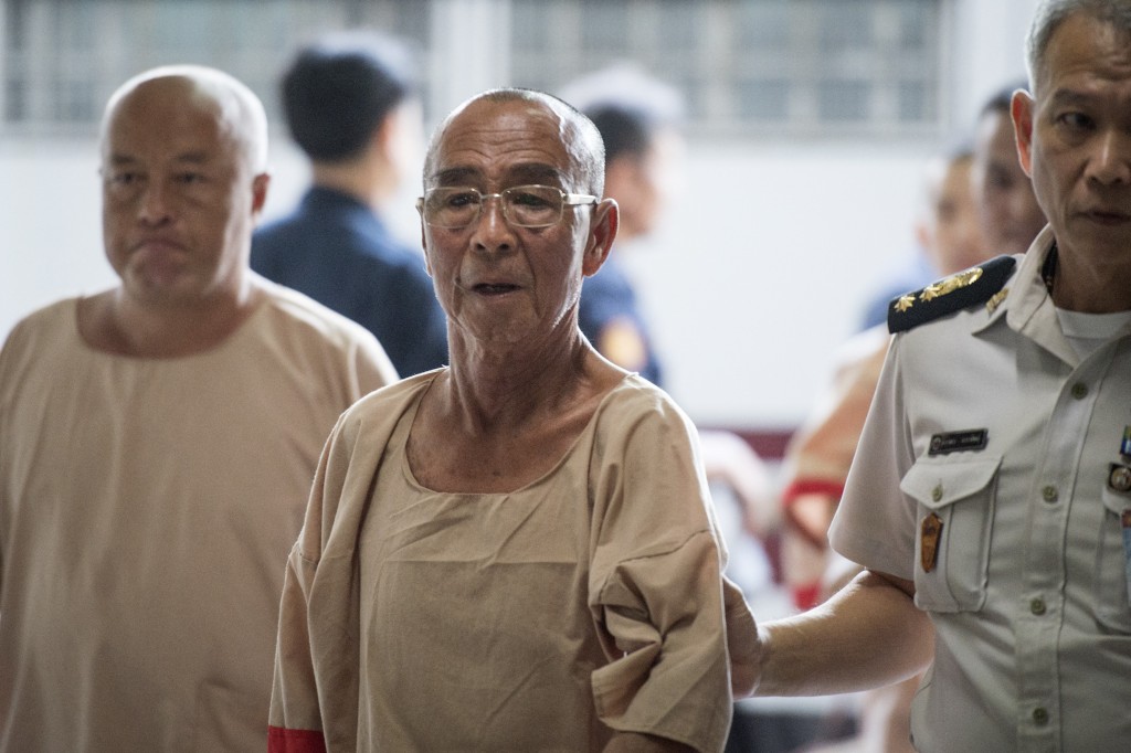 Photo by LILLIAN SUWANRUMPHA / AFP  Laota Seanlee (C), a controversial guerilla fighter long accused of playing a key role in the Golden Triangle drugs trade, is escorted into a Criminal Court in Bangkok on December 13, 2017.