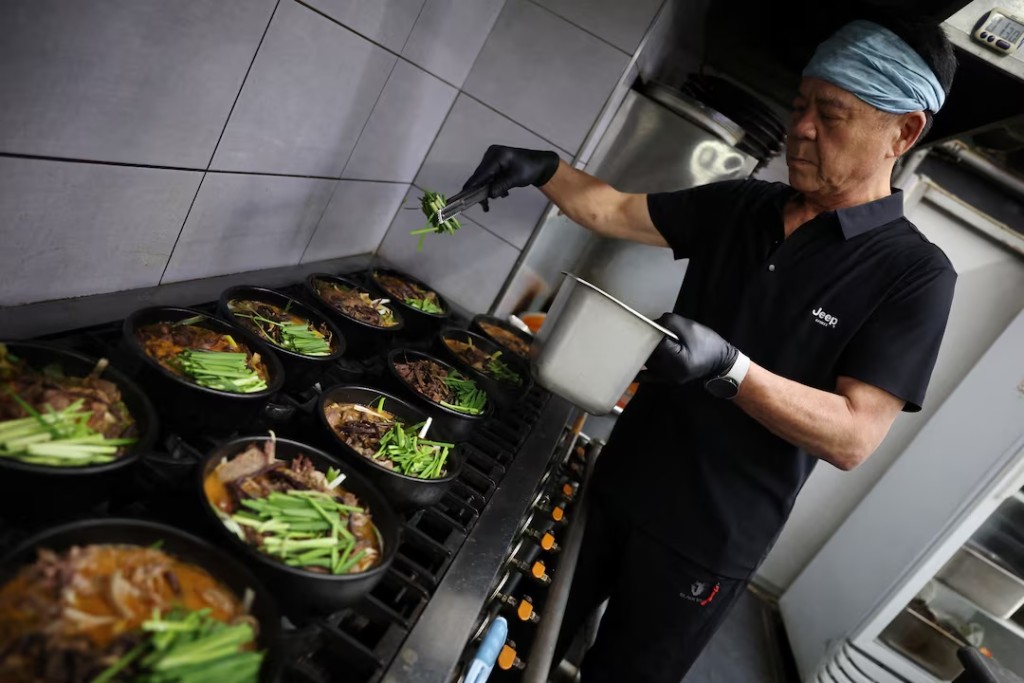 Lee Kang-chun, a restaurant owner who sells dog meat and black goat meat stews, cooks dishes during Malbok, the last of Korea's traditional hottest days of summer, at his restaurant in Seongnam, South Korea, August 14, 2026. REUTERS/Kim Hong-Ji