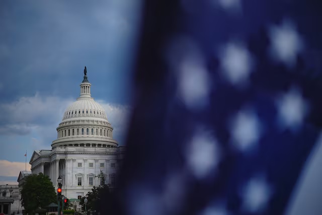 The U.S. Capitol stands behind a U.S. flag on Capitol Hill in Washington, D.C., U.S., June 29, 2025. REUTERS/Ken Cedeno/ File Photo
