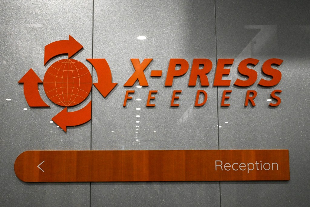 This photograph taken on September 22, 2025 shows the logo of global shipping carrier X-Press Feeders in the lobby of its office in Singapore. A Singapore shipping company told AFP on September 23, 2025, it will refuse to pay Sri Lankan court-ordered damages of 1 billion USD for causing that country's worst case of environmental pollution. (Photo by Roslan RAHMAN / AFP)
