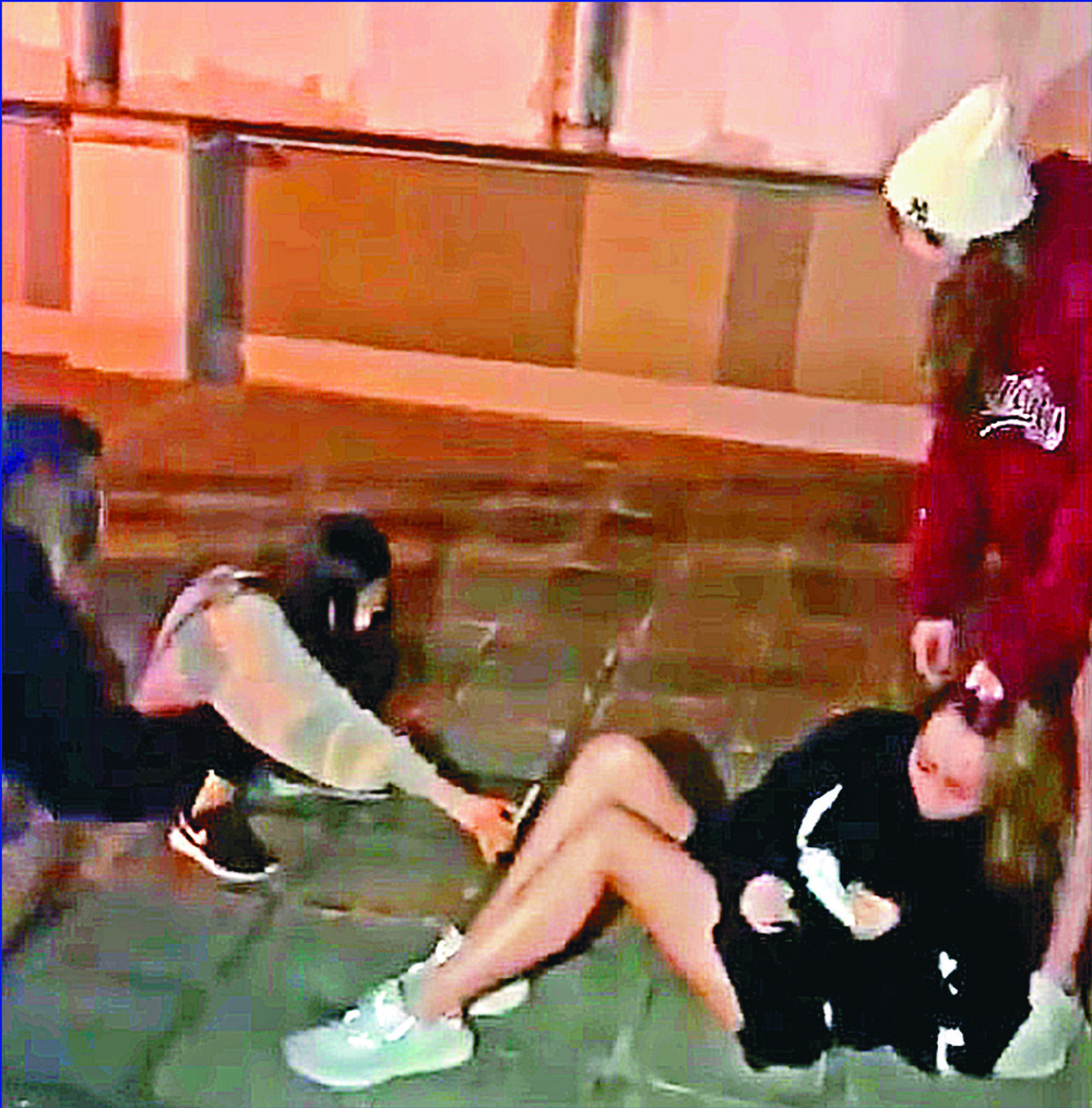 A video grab allegedly shows a gang attacking a young woman. A video grab allegedly shows a gang attacking a young woman.