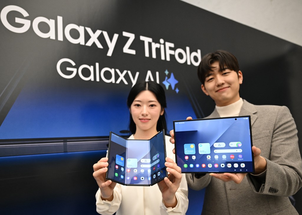 Photo by JUNG YEON-JE / AFP  Promoters show Samsung Galaxy Z TriFold smartphones during a launch event at a Samsung store in Seoul on December 2, 2025.