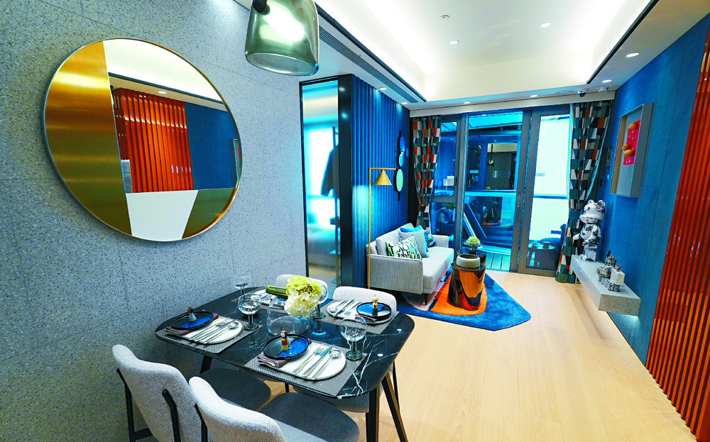 VIBRANT VIBE: The living and dining areas come alive in hues of deep blue and orange, and the color theme extends across the bedrooms as well.