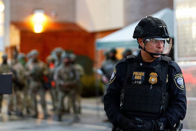 A Federal Protective Service police officer guards the gate of a ICE facility in Portland, Oregon, U.S. October 26, 2025. REUTERS/John Rudoff/File Photo