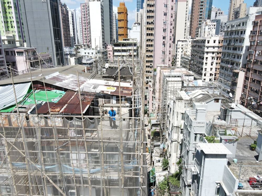 Hing Lam Leung stands outside his home atop a Hong Kong high-rise. The city’s leaders have pledged to provide more public housing, but solutions remain years away. (Bloomberg) 